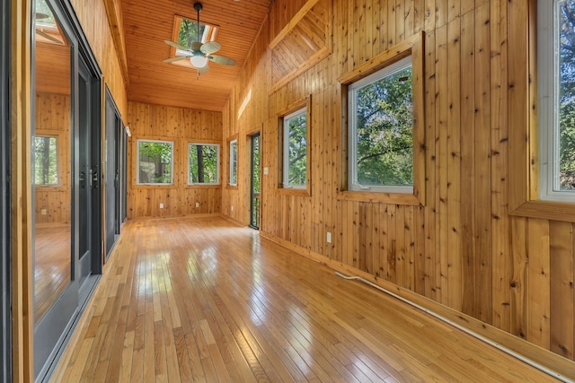 unfurnished sunroom with lofted ceiling, ceiling fan, and wooden ceiling