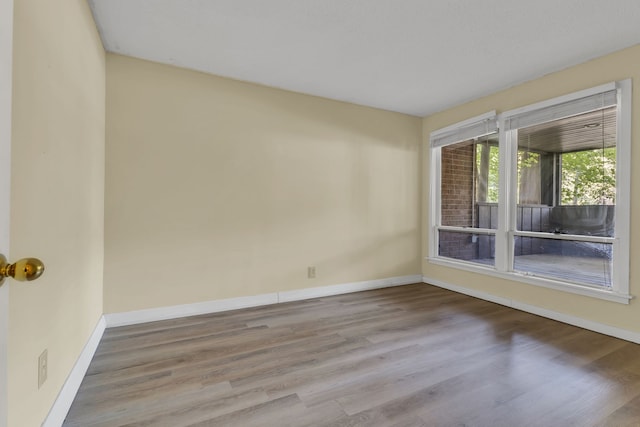 unfurnished room with hardwood / wood-style flooring