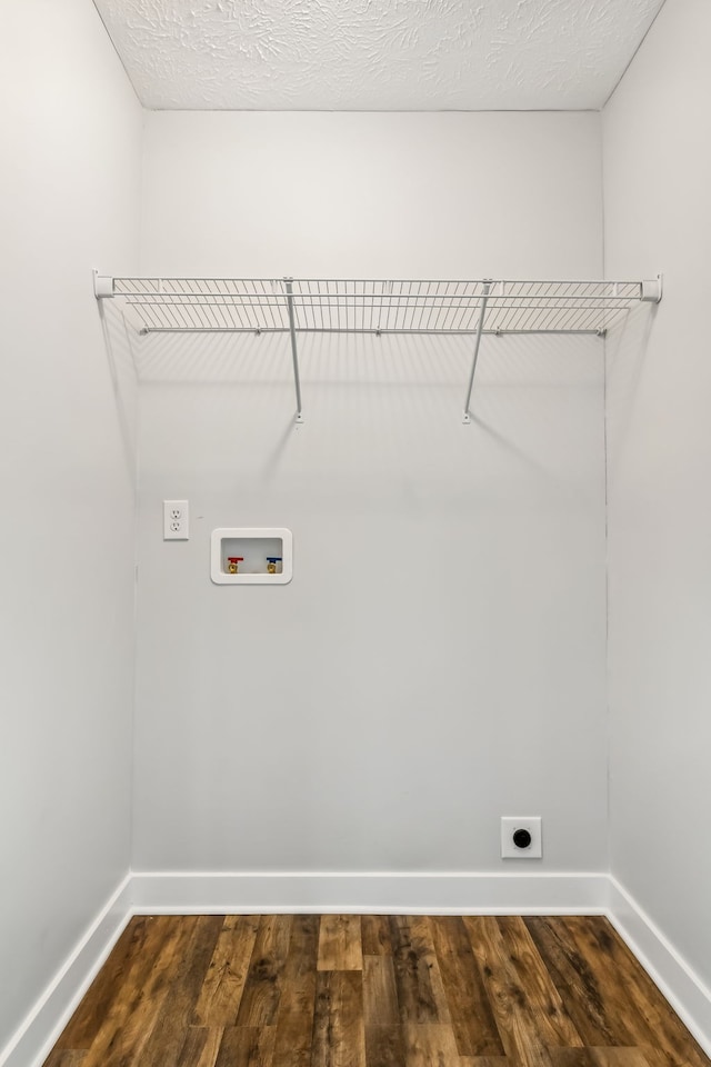 clothes washing area featuring washer hookup, hookup for an electric dryer, a textured ceiling, and dark hardwood / wood-style floors