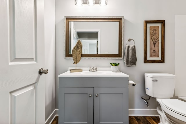 bathroom featuring vanity, hardwood / wood-style floors, and toilet