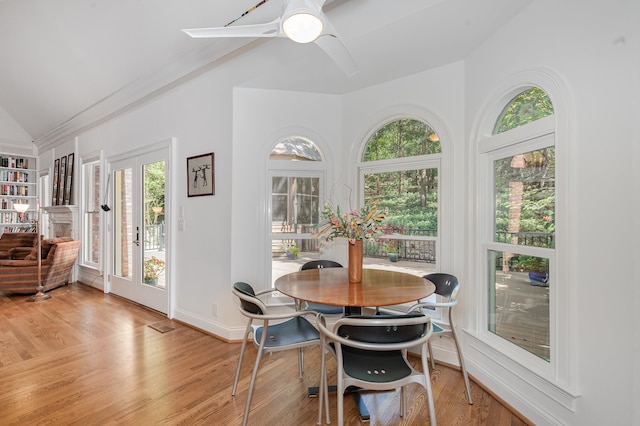 dining room with ceiling fan, light wood-type flooring, and vaulted ceiling