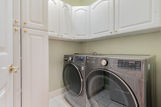 clothes washing area featuring cabinets, washing machine and clothes dryer, and light tile patterned flooring