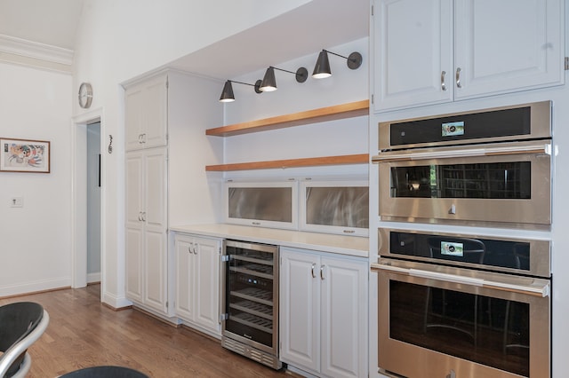 kitchen with light hardwood / wood-style floors, double oven, wine cooler, and white cabinets