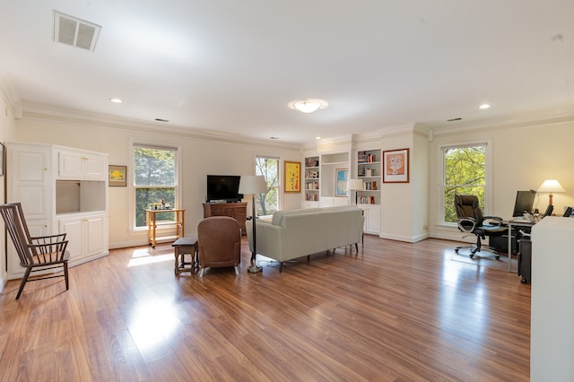 living room with ornamental molding and light hardwood / wood-style flooring