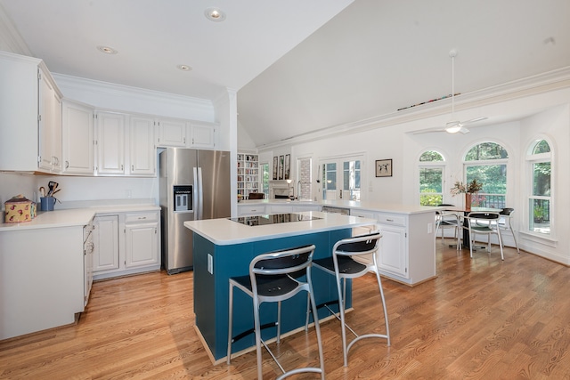 kitchen featuring stainless steel fridge, a kitchen island, and white cabinets