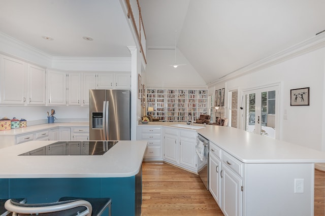 kitchen featuring light hardwood / wood-style flooring, appliances with stainless steel finishes, white cabinetry, and a kitchen island