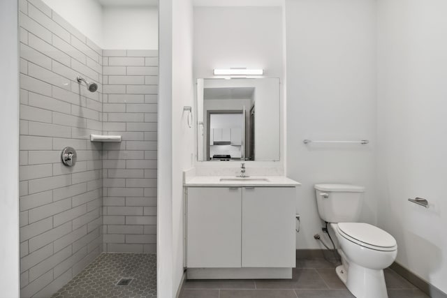 bathroom featuring tiled shower, vanity, toilet, and tile patterned floors