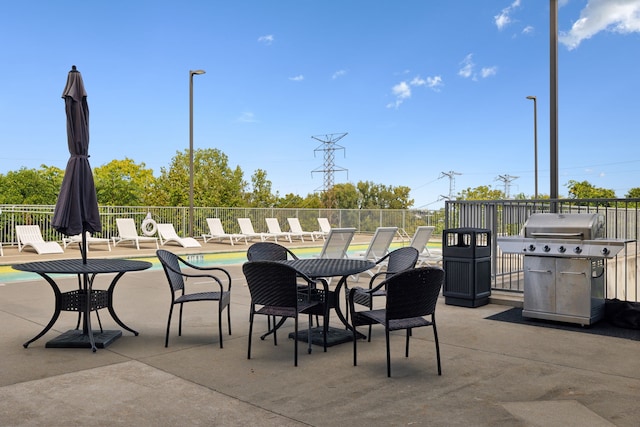 view of patio / terrace featuring a community pool and a grill