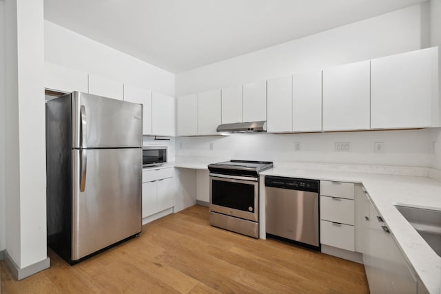 kitchen featuring appliances with stainless steel finishes, light wood-type flooring, and white cabinetry