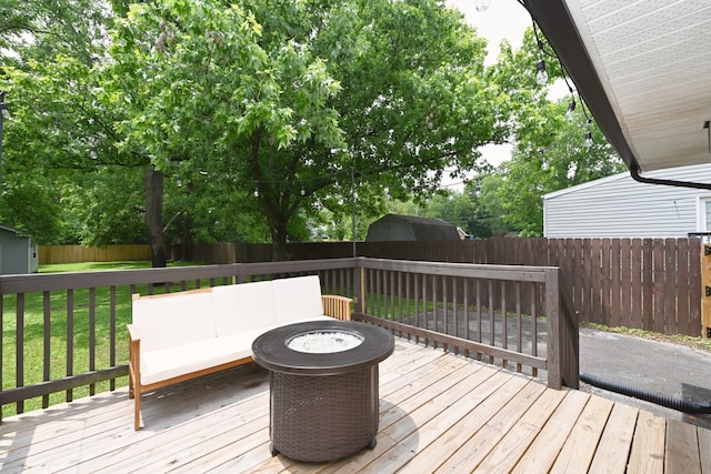 wooden terrace with a yard and a fire pit