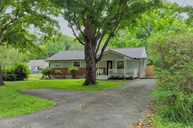 ranch-style home with a front lawn and a porch