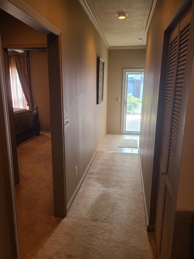 corridor featuring a textured ceiling, crown molding, and light carpet