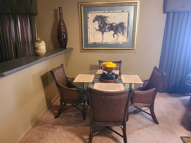 dining space featuring light carpet