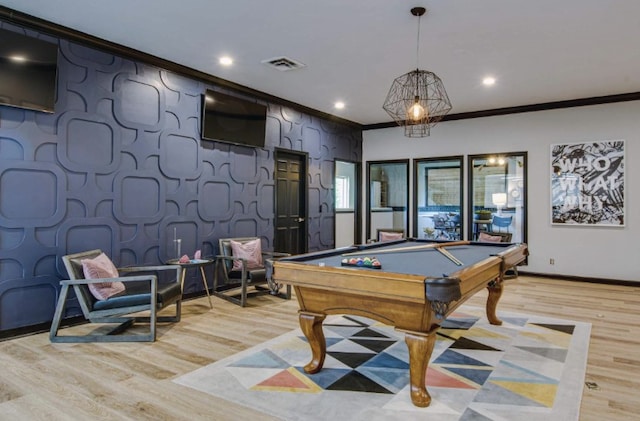 game room with light wood-type flooring, crown molding, and pool table