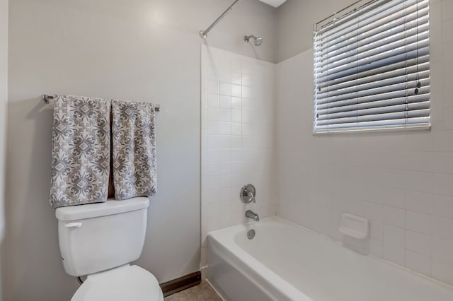 bathroom featuring tiled shower / bath combo and toilet