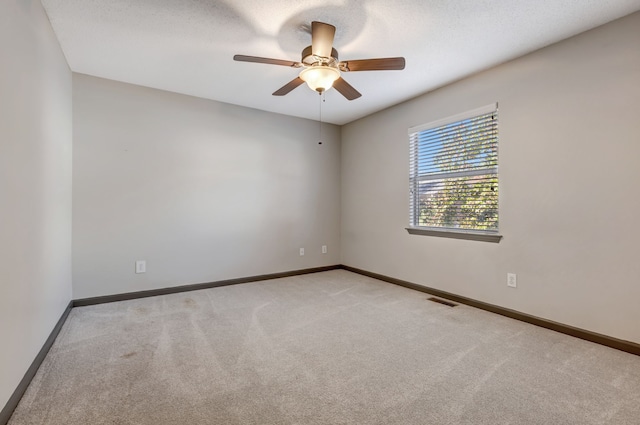 carpeted spare room with ceiling fan and a textured ceiling