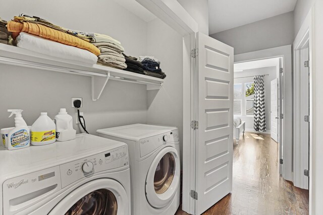 clothes washing area featuring dark hardwood / wood-style floors and washer and clothes dryer