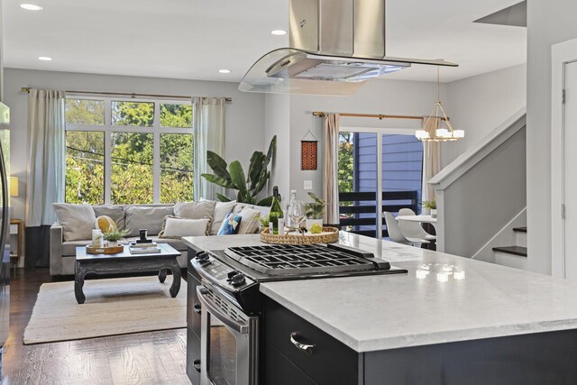 kitchen featuring stainless steel gas range oven, dark hardwood / wood-style flooring, pendant lighting, and a chandelier