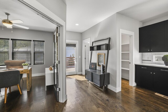 interior space with ceiling fan, dark hardwood / wood-style flooring, decorative backsplash, and a healthy amount of sunlight