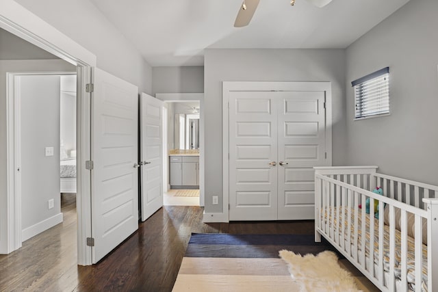 bedroom featuring connected bathroom, dark hardwood / wood-style floors, ceiling fan, and a closet