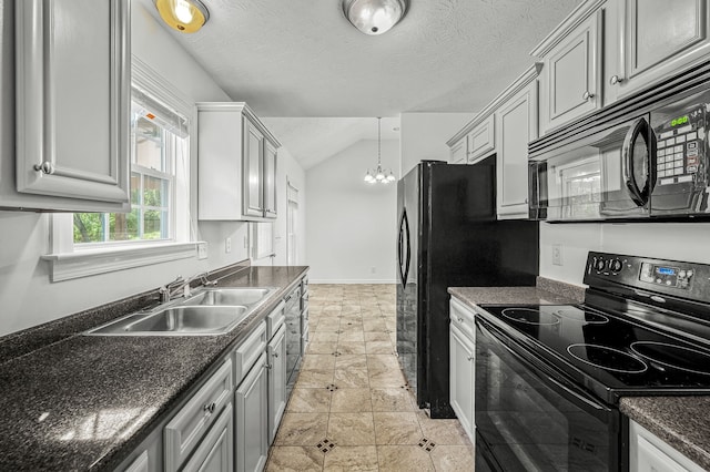 kitchen with lofted ceiling, hanging light fixtures, black appliances, sink, and a chandelier