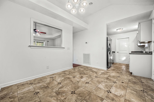 unfurnished dining area featuring ceiling fan and vaulted ceiling