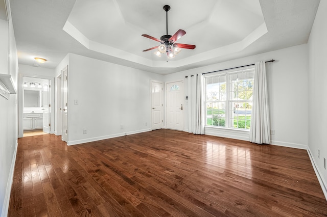 interior space featuring hardwood / wood-style flooring, a tray ceiling, and ceiling fan