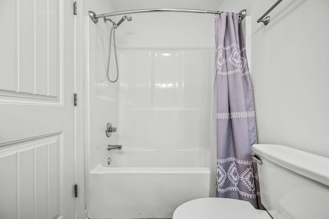 bathroom with shower / tub combo with curtain and toilet