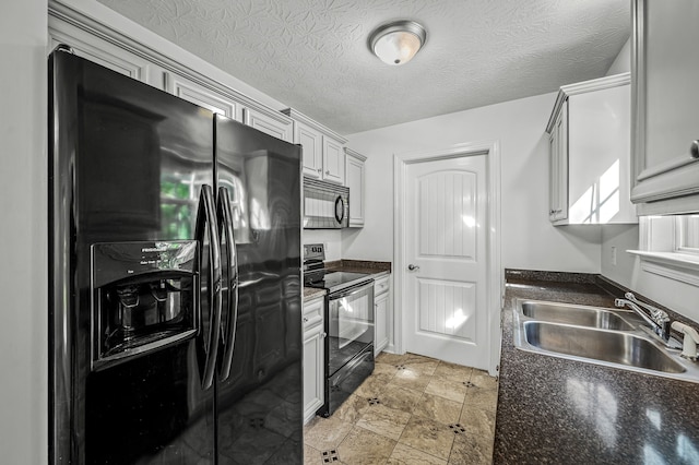 kitchen featuring a textured ceiling, black appliances, and sink