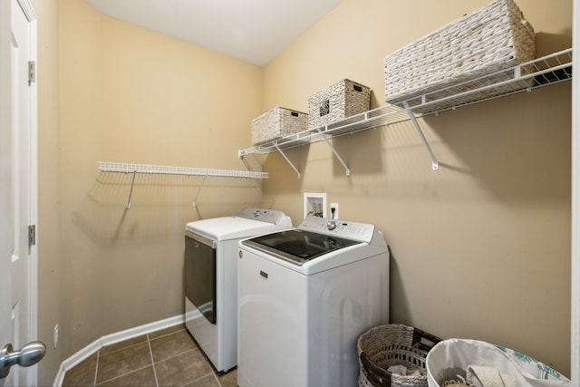 laundry area with dark tile patterned floors and washing machine and dryer