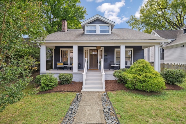 view of front of house with a front yard and covered porch