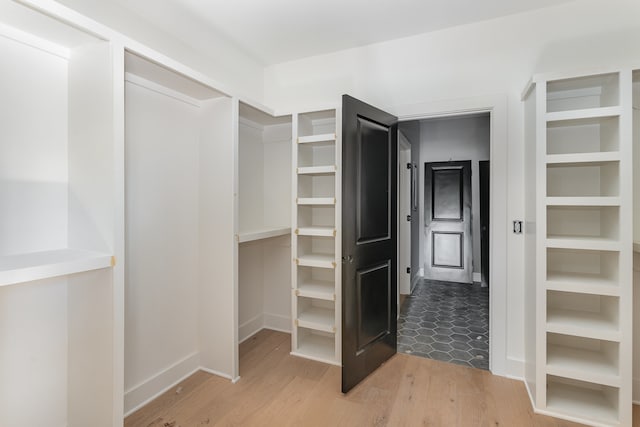 spacious closet with light hardwood / wood-style flooring