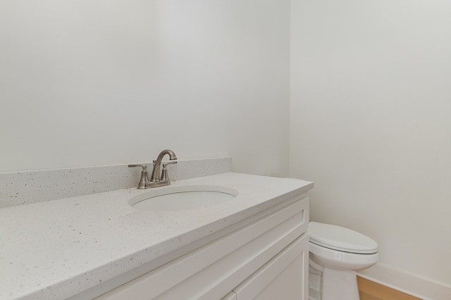 bathroom featuring vanity, wood-type flooring, and toilet