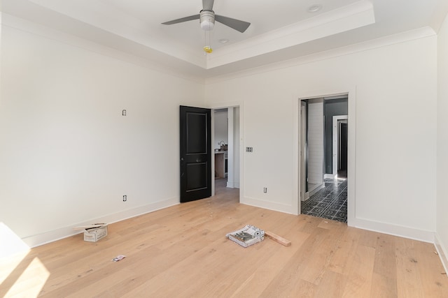 unfurnished bedroom featuring hardwood / wood-style flooring, a raised ceiling, ceiling fan, and ornamental molding