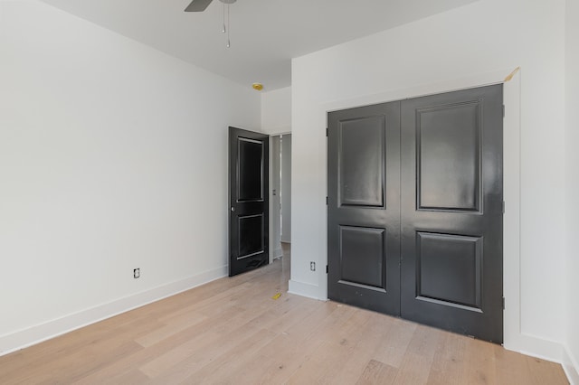 unfurnished bedroom with light wood-type flooring, a closet, and ceiling fan