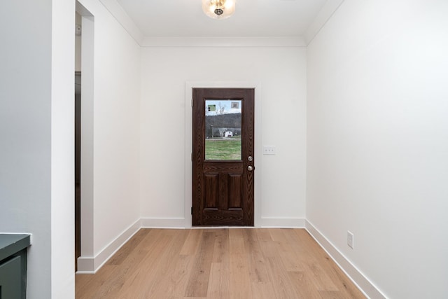 doorway with light hardwood / wood-style floors and ornamental molding