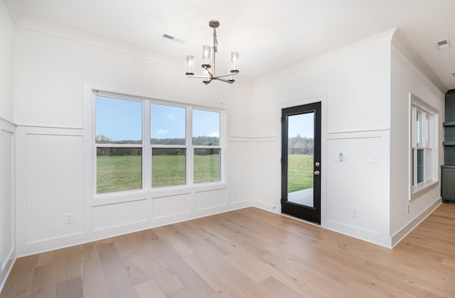 interior space featuring a chandelier, crown molding, and light hardwood / wood-style flooring