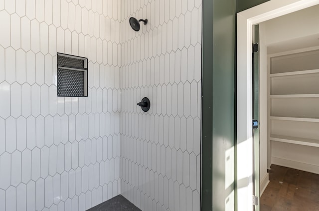 bathroom featuring wood-type flooring and tiled shower