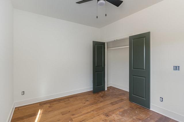 unfurnished bedroom featuring a closet, hardwood / wood-style flooring, and ceiling fan