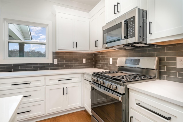 kitchen with backsplash, light hardwood / wood-style flooring, white cabinets, and appliances with stainless steel finishes