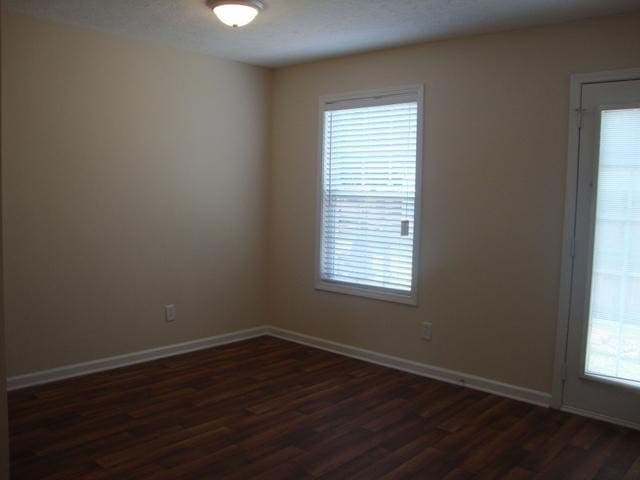 empty room with dark wood-type flooring