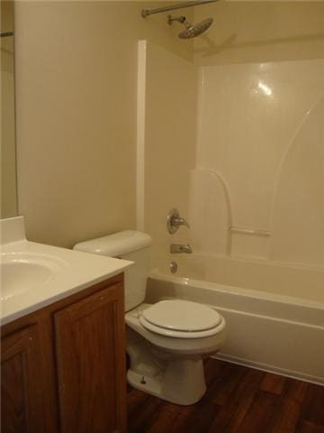 full bathroom featuring hardwood / wood-style floors, vanity, bathtub / shower combination, and toilet