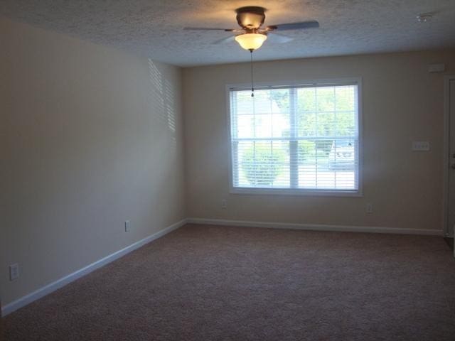 spare room with carpet, ceiling fan, and a textured ceiling