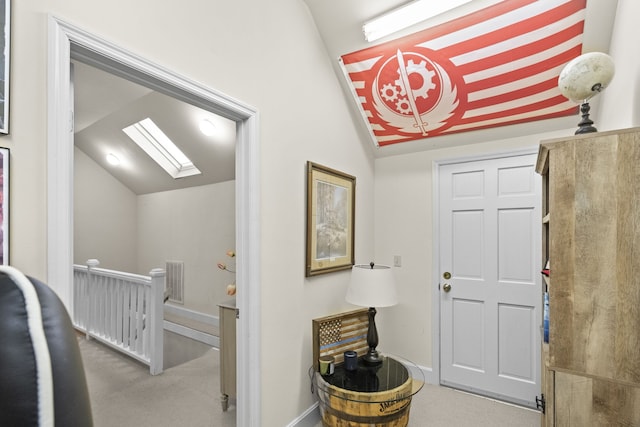 entrance foyer with vaulted ceiling with skylight and carpet