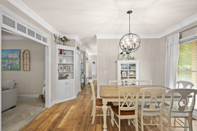 dining area featuring an inviting chandelier, light wood-type flooring, and crown molding