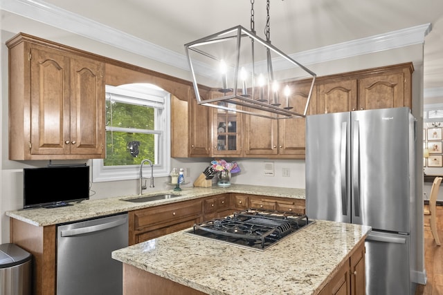 kitchen with decorative light fixtures, appliances with stainless steel finishes, crown molding, and sink