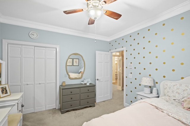 carpeted bedroom with ornamental molding, a closet, and ceiling fan