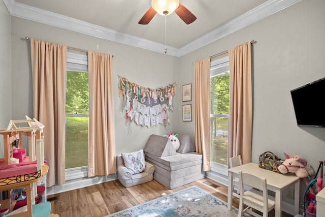 playroom with ceiling fan, ornamental molding, and hardwood / wood-style floors