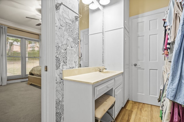 bathroom with ceiling fan, vanity, crown molding, and hardwood / wood-style floors