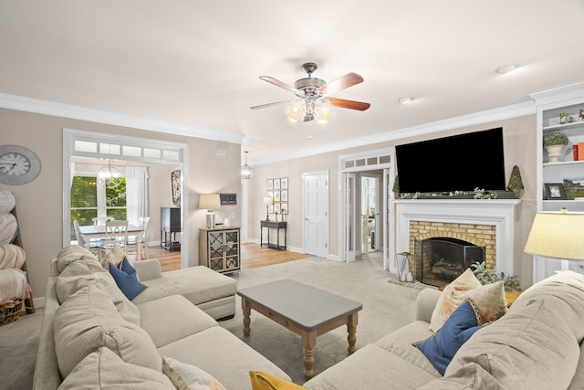 living room featuring ceiling fan, light wood-type flooring, a brick fireplace, and crown molding